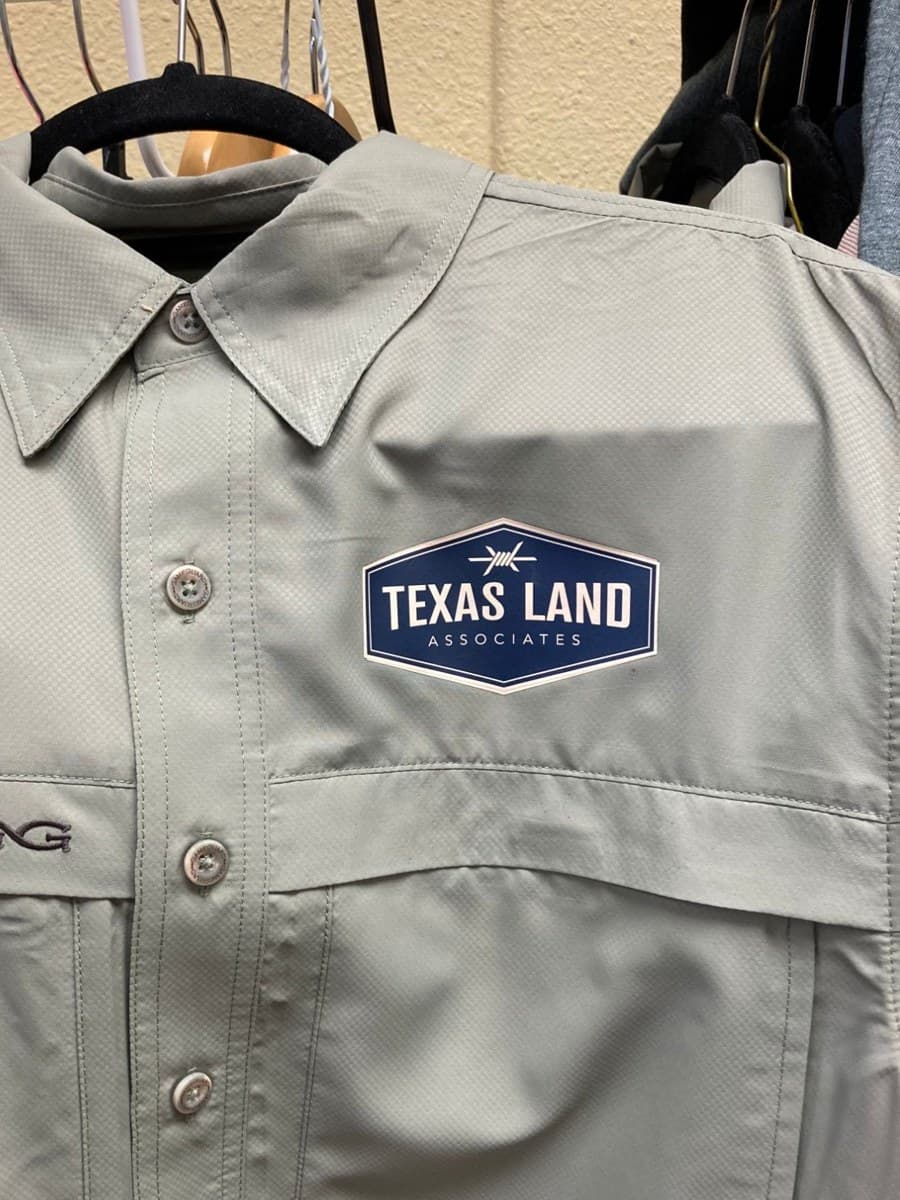 Texas Land Associates logo on a performance button-up shirt